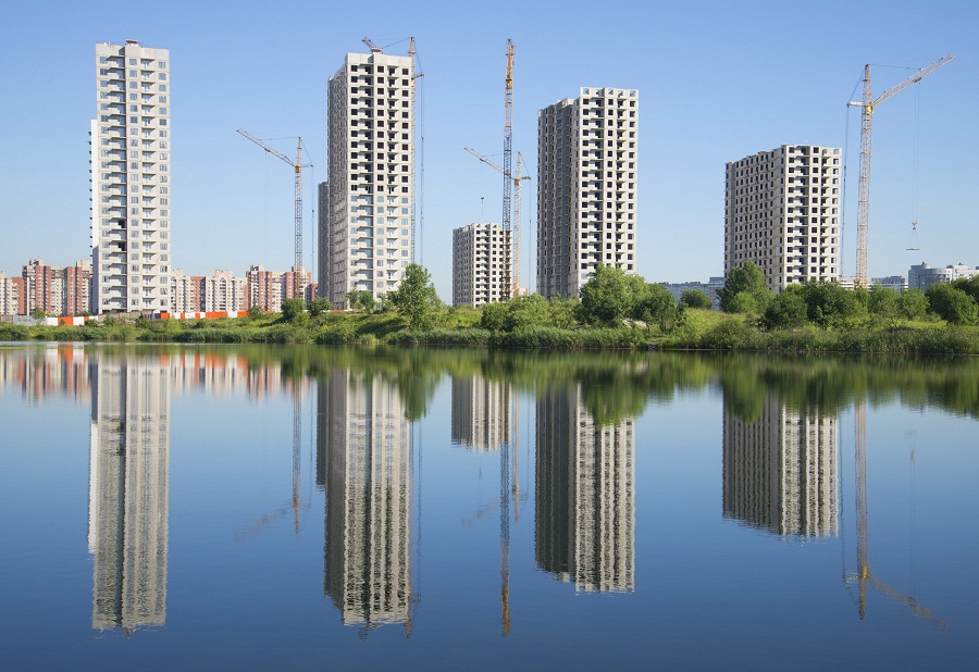Четыре строящихся здания на берегу озера. Санкт-Петербург